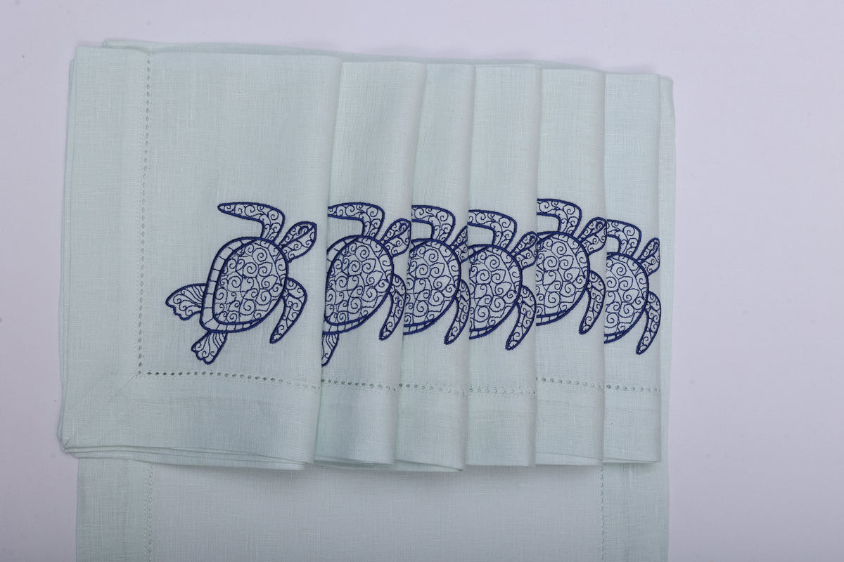Powder blue linen placemats and napkins with embroidered turtle.