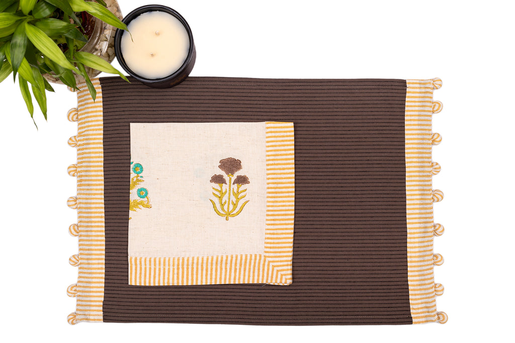 Brown linen placemat with striped flange and printed linen napkin.