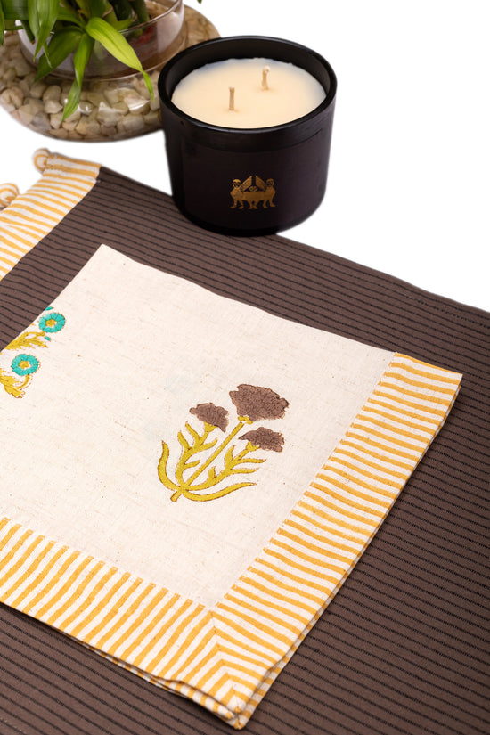 Brown linen placemat with striped flange and printed linen napkin.