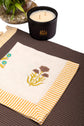 Brown linen placemat with striped flange and printed linen napkin.