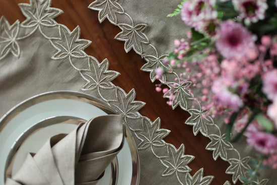 Brown linen runner with gold cutwork embroidery.