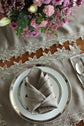 Brown linen placemats and napkins with gold  cutwork embroidery.