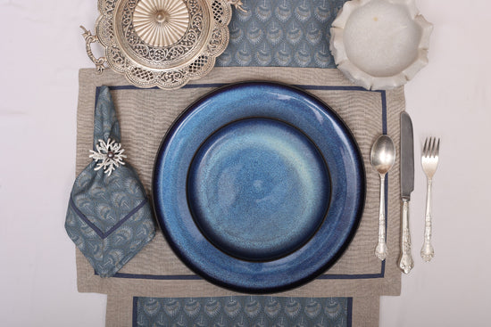 Natural linen placemats with blue peacock print linen napkin.