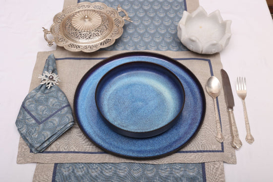 Natural linen placemats with blue peacock print linen napkin.