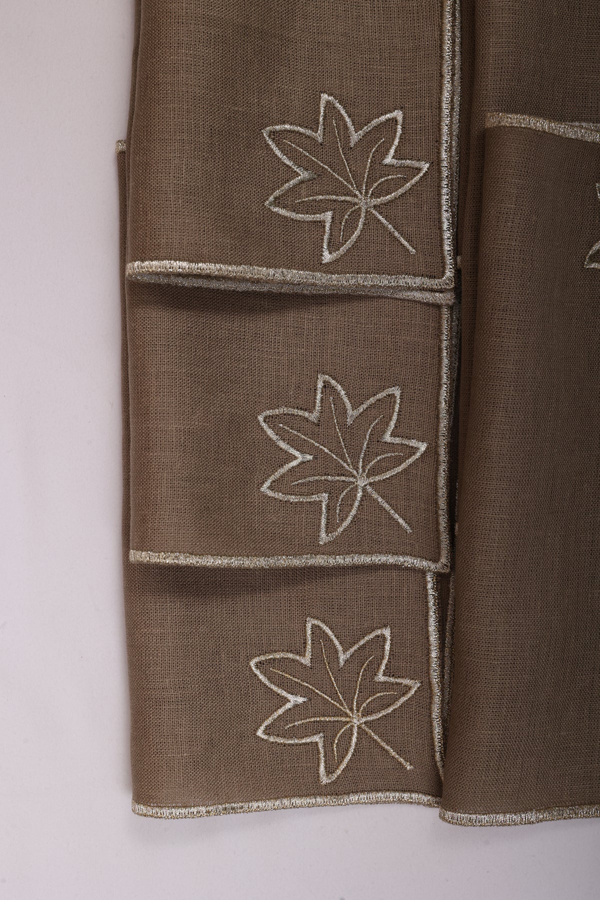 Brown linen maple leaf embroidered cocktail napkin.