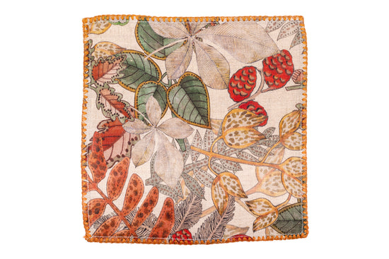 White linen cocktail napkins with leaves printed.