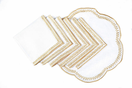 White linen gold embroidered round placemats and napkins.