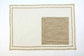 Embroidered cream linen placemats with  beige striped linen napkins.