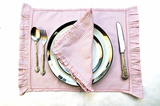 Pink striped linen placemats and napkins with ruffles.