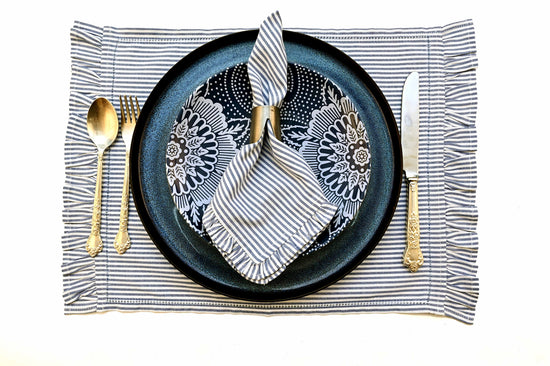 Navy blue striped linen  placemats and  napkins with ruffles.