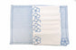 Blue striped placemats and white linen napkins with floral embroidery.