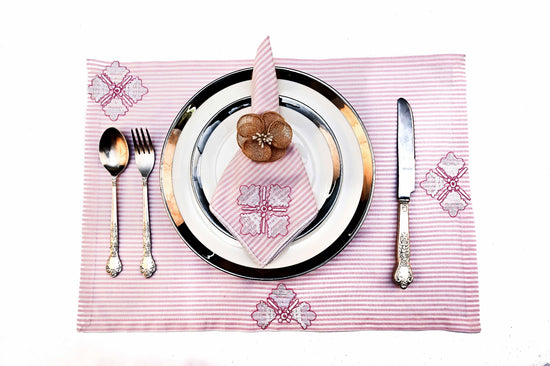 Pink striped placemats and napkins with motif embroidery.