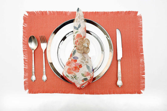 Rust peach linen placemats with floral printed linen napkins.