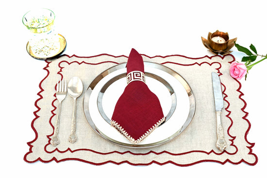 Natural linen  placemats with  maroon linen  embroidered  napkins.