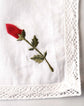 White linen cocktail napkins with rosebud embroidery.