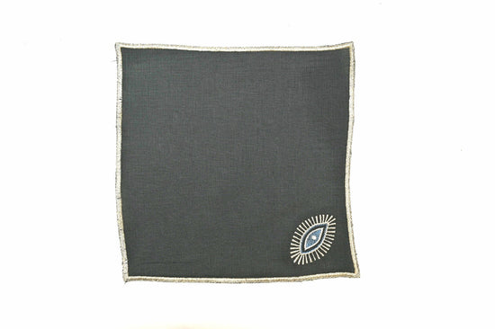 Green linen cocktail napkins with silver evil eye embroidered.