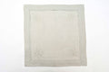 Grey linen cocktail napkins with silver maple leaf embroidery.