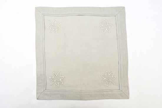 Grey linen cocktail napkins with silver maple leaf embroidery.