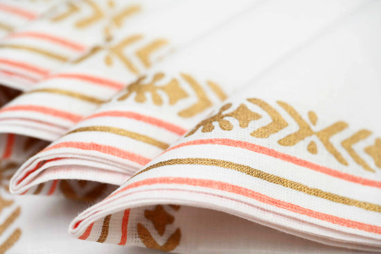 White linen placemats and napkins with delicate pink block print.