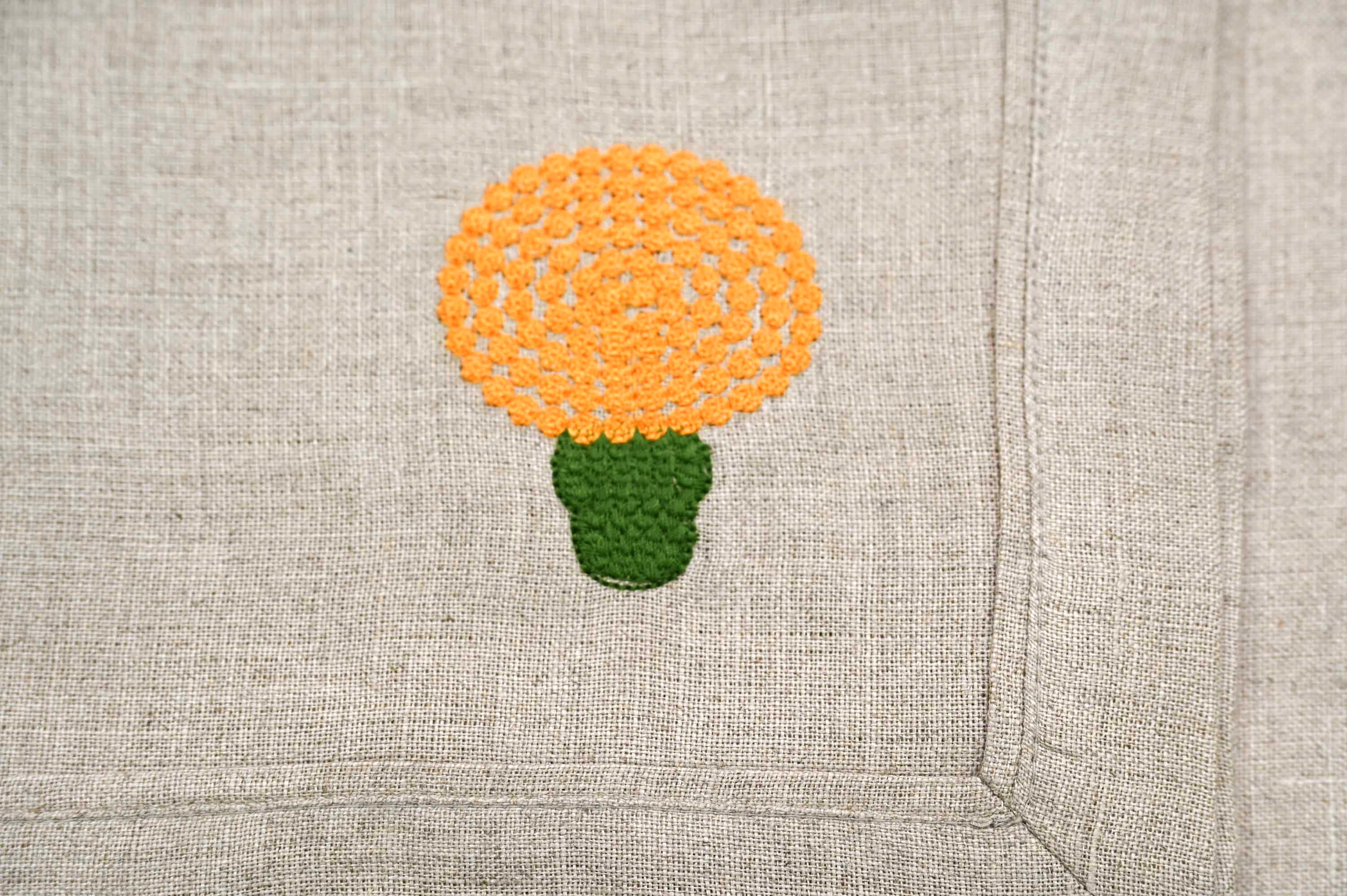Natural linen placemats and napkins with marigold embroidery.