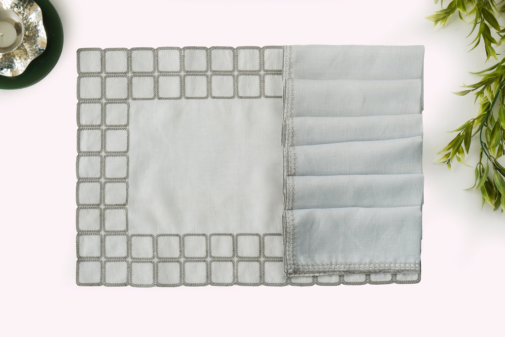 Powder blue embroidered placemats with matching linen napkins.