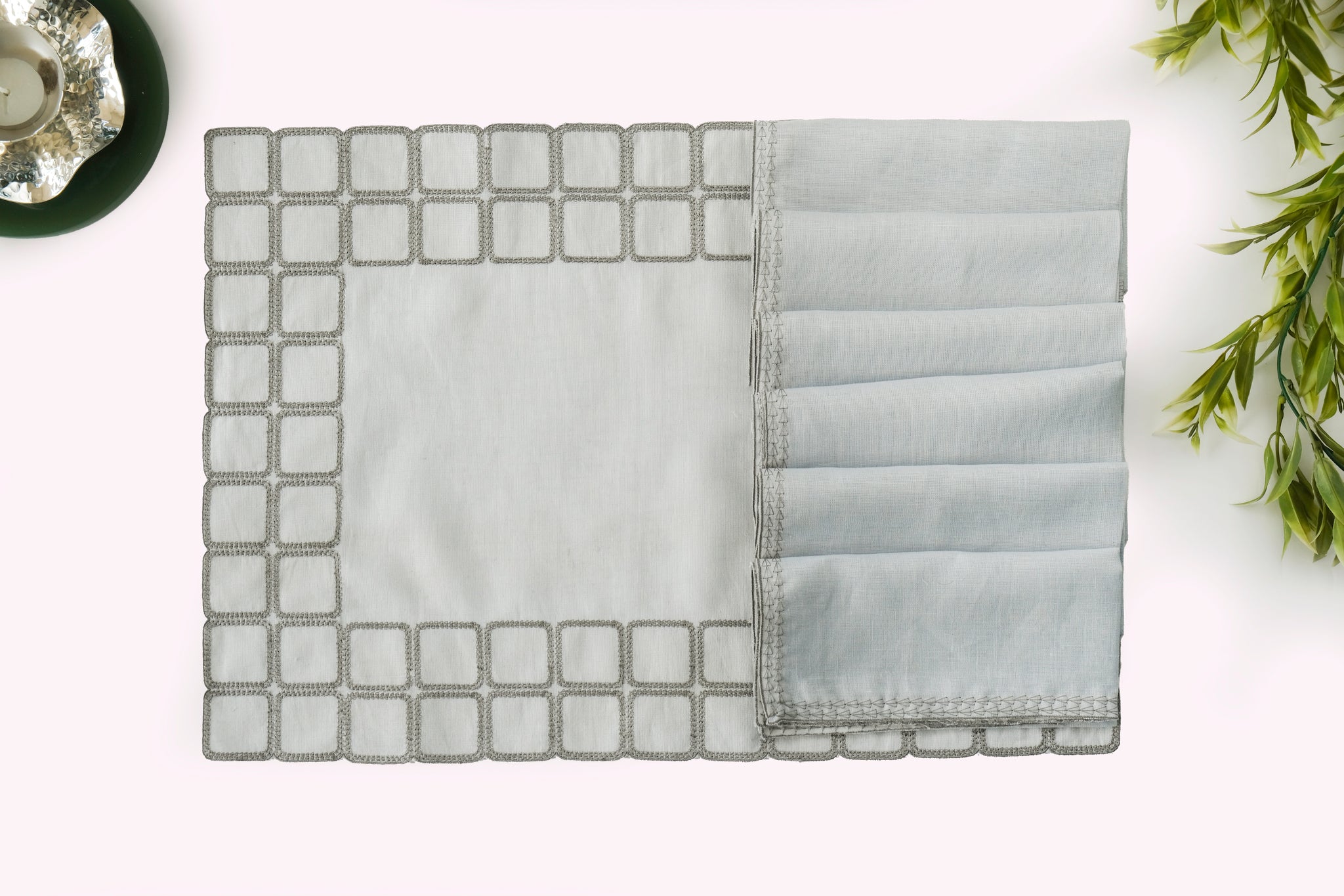 Powder blue embroidered placemats with matching linen napkins.