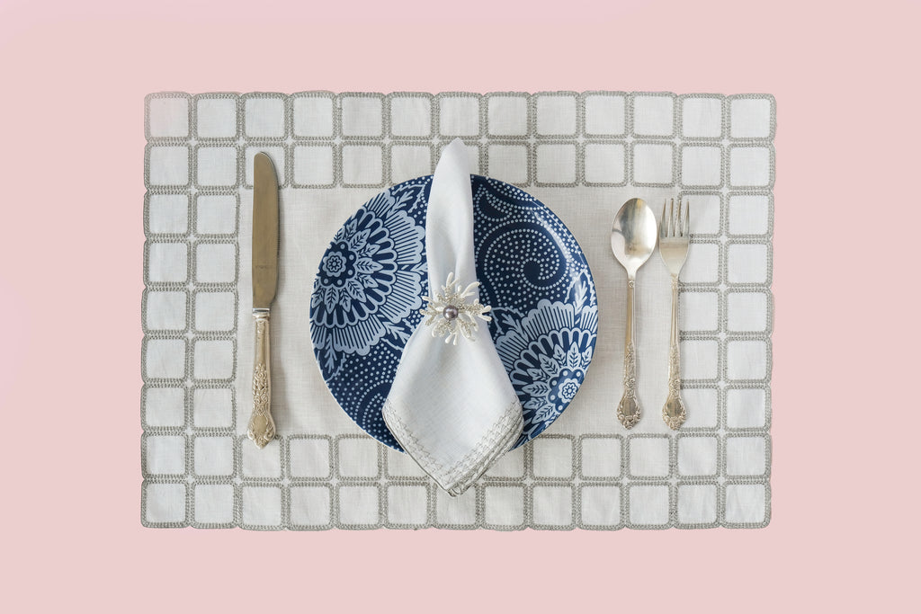 Powder blue embroidered placemats with matching linen napkins.