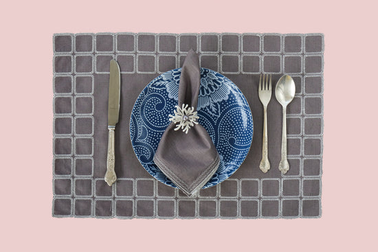 Grey linen embroidered placemats with matching linen napkins.