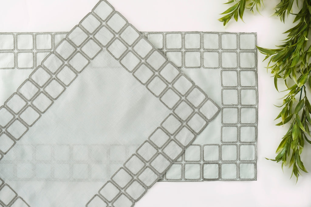 Powder blue embroidered placemats with matching linen napkins.