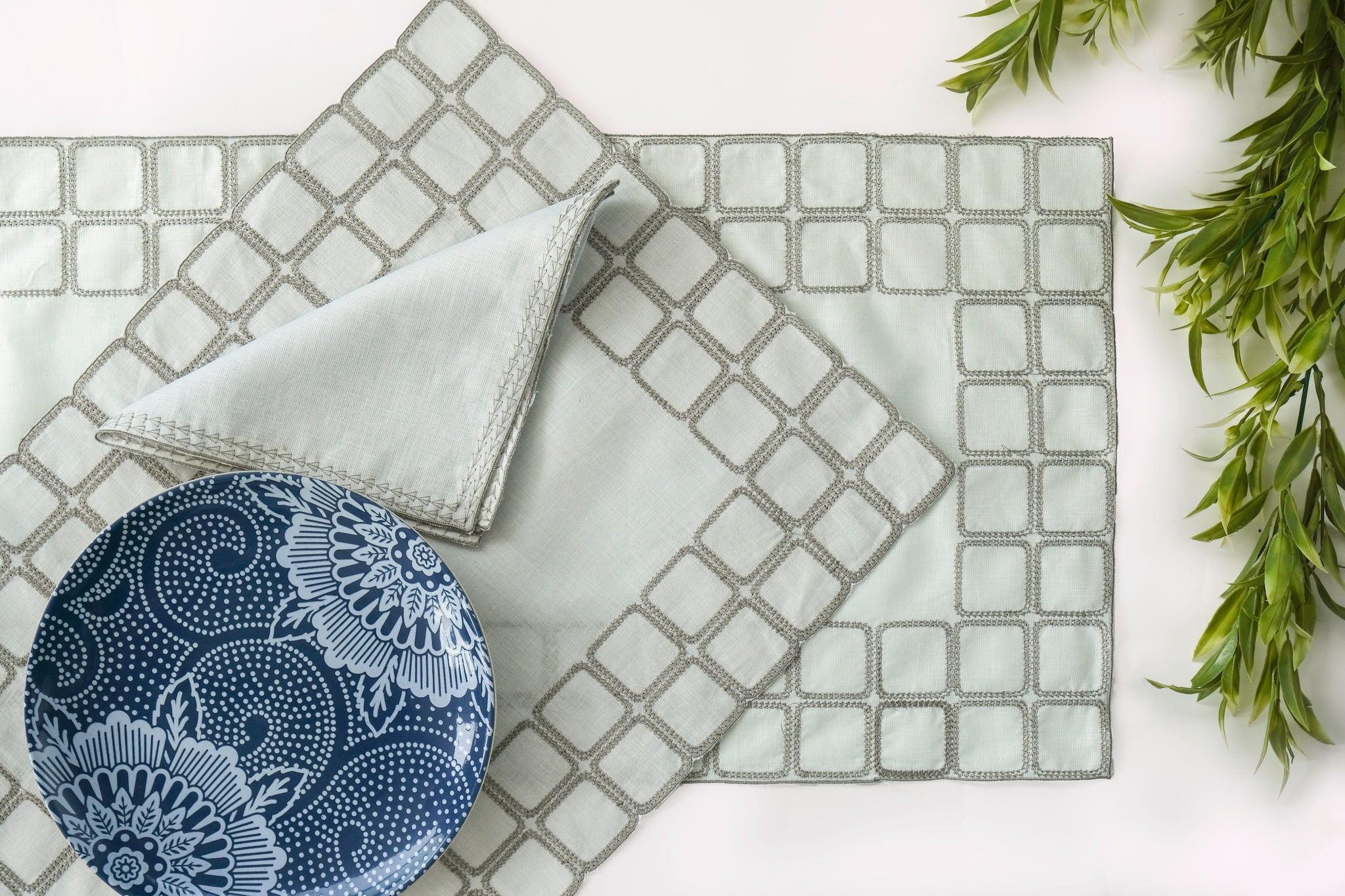 Powder blue embroidered placemats with matching linen napkins.