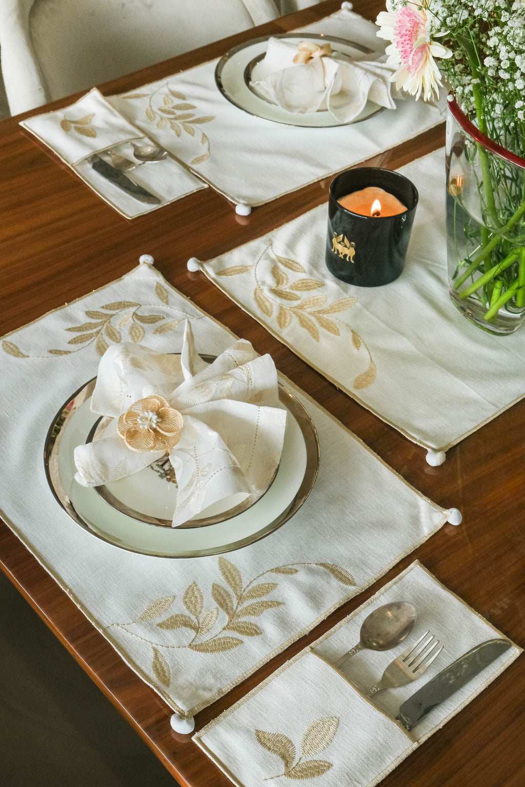 Cream linen embroidered cutlery holders.
