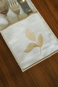 Cream linen embroidered cutlery holders.