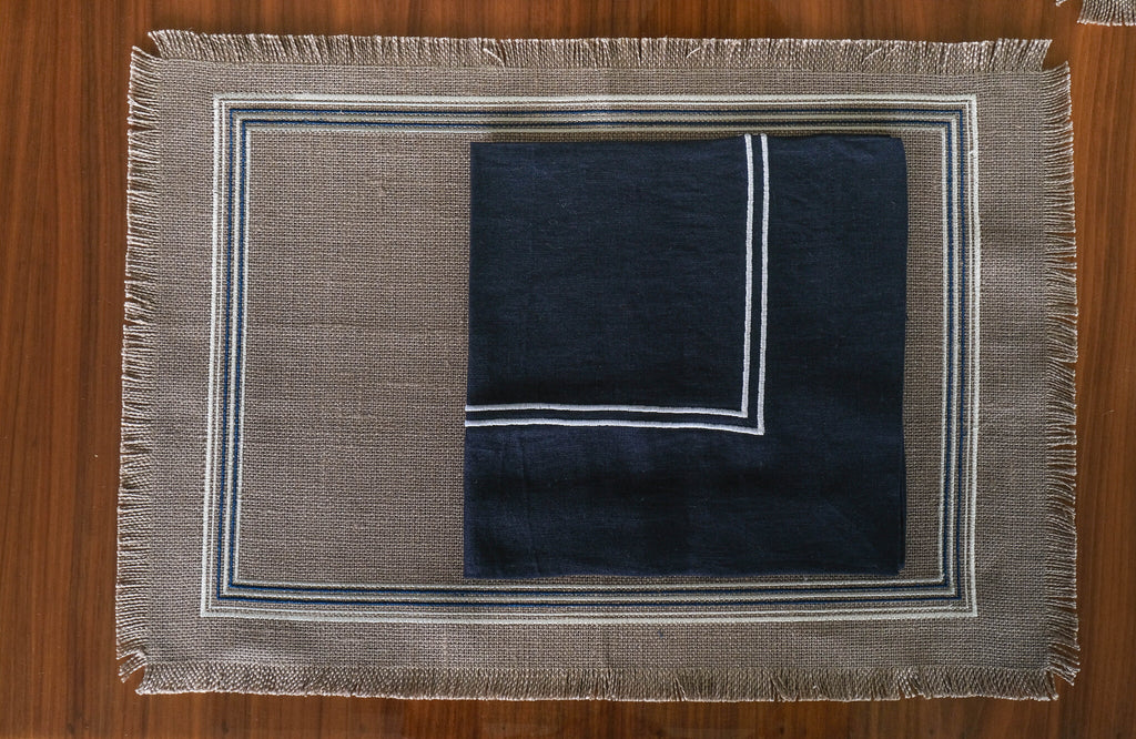 Grey linen placemats with navy blue  linen napkins.