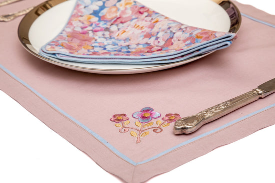 Pink linen  placemats with pink floral linen napkins.