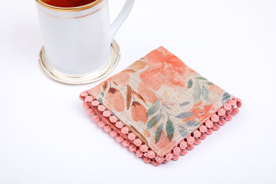 Pink floral and blue leaf printed linen cocktail napkins.