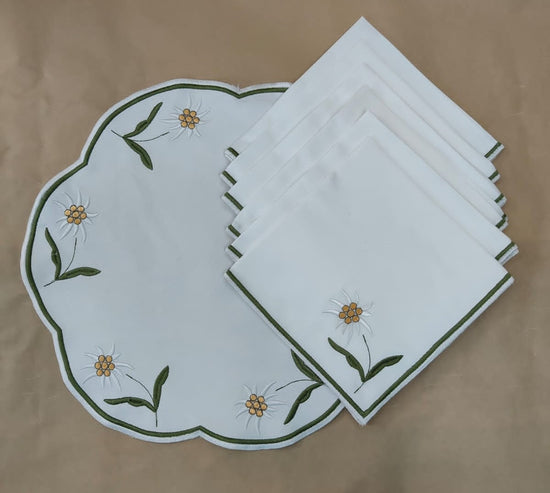 White linen round flower embroidered placemats and napkins.