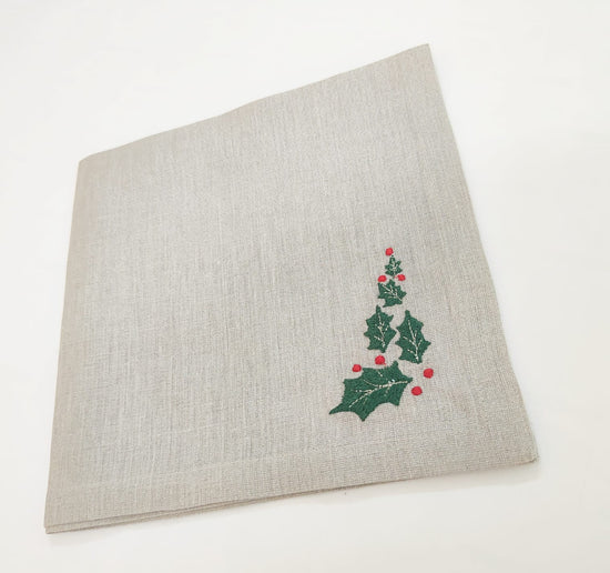 Linen christmas dinner napkins with embroidered holly leaf.