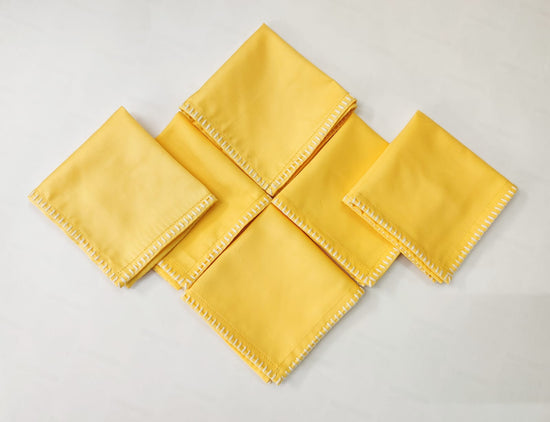 Yellow cotton cocktail napkins with delicate embroidery.