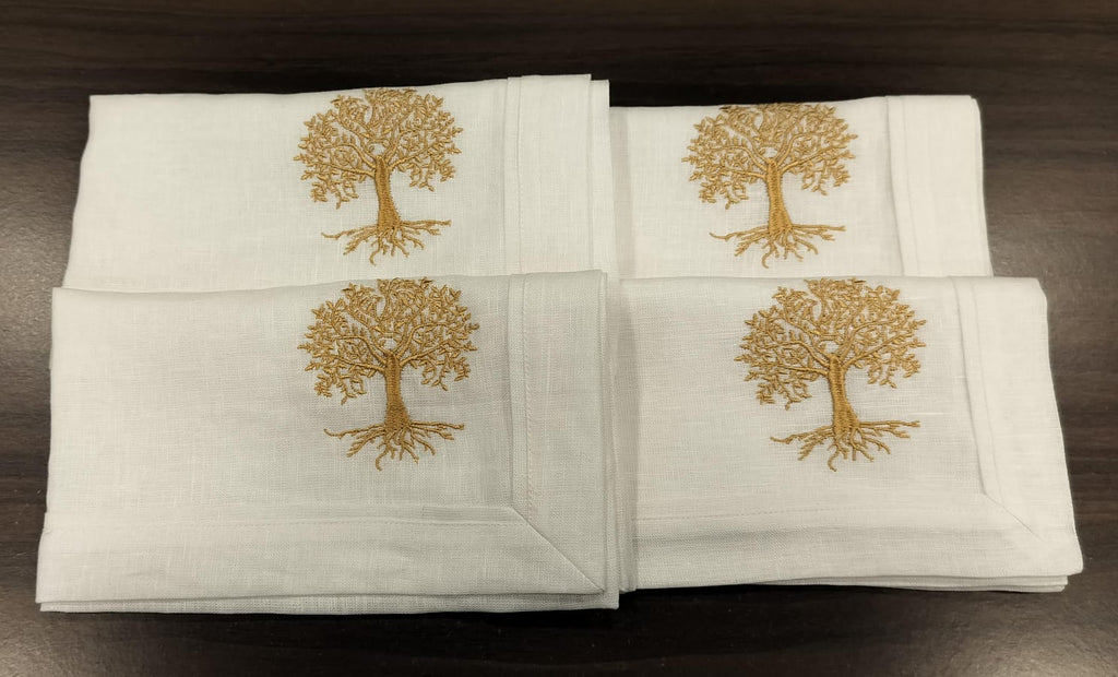 White linen  dinner napkins with tree embroidery.