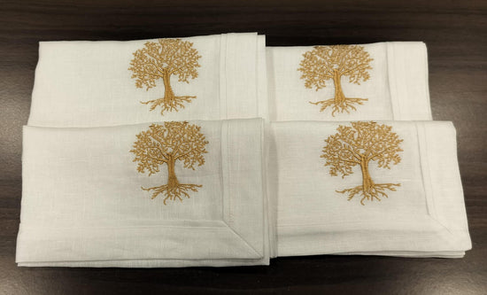 White linen  dinner napkins with tree embroidery.