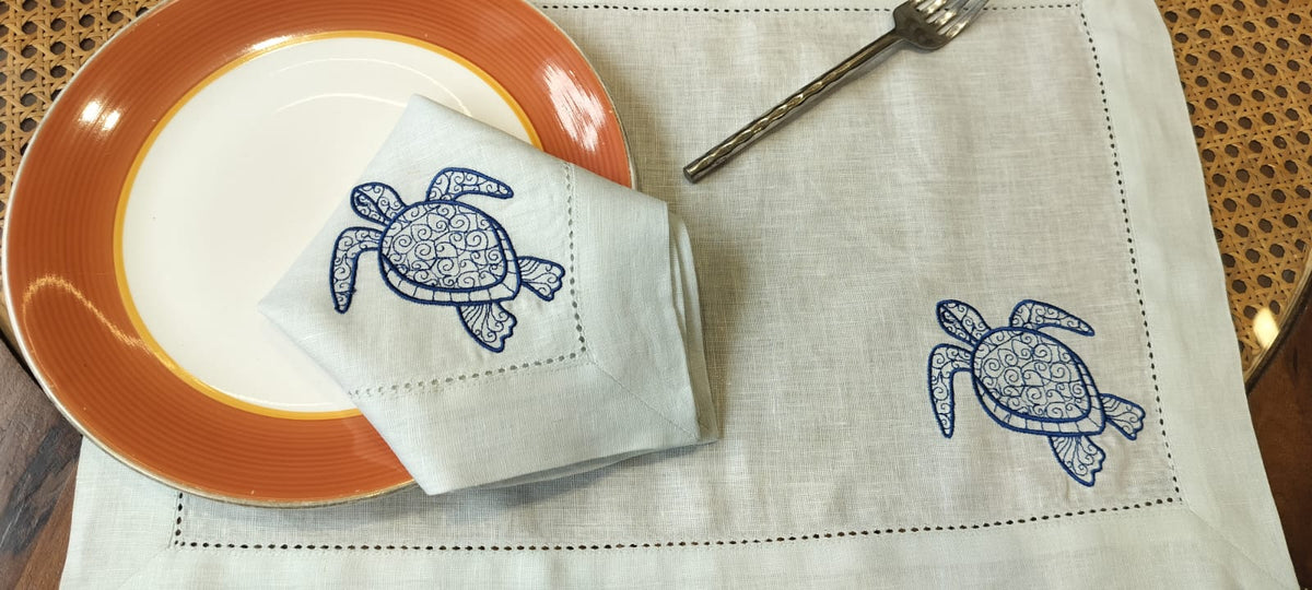 Powder blue linen placemats and napkins with embroidered turtle.