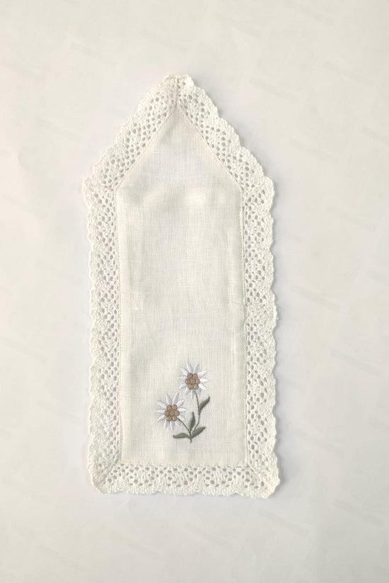 White cutlery holder with floral embroidery.