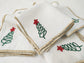 White linen cocktail napkins with christmas tree embroidered.