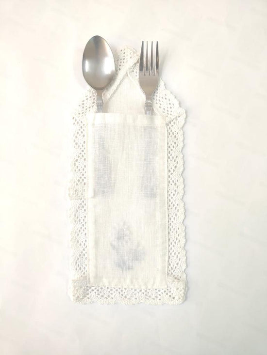 White cutlery holder with floral embroidery.