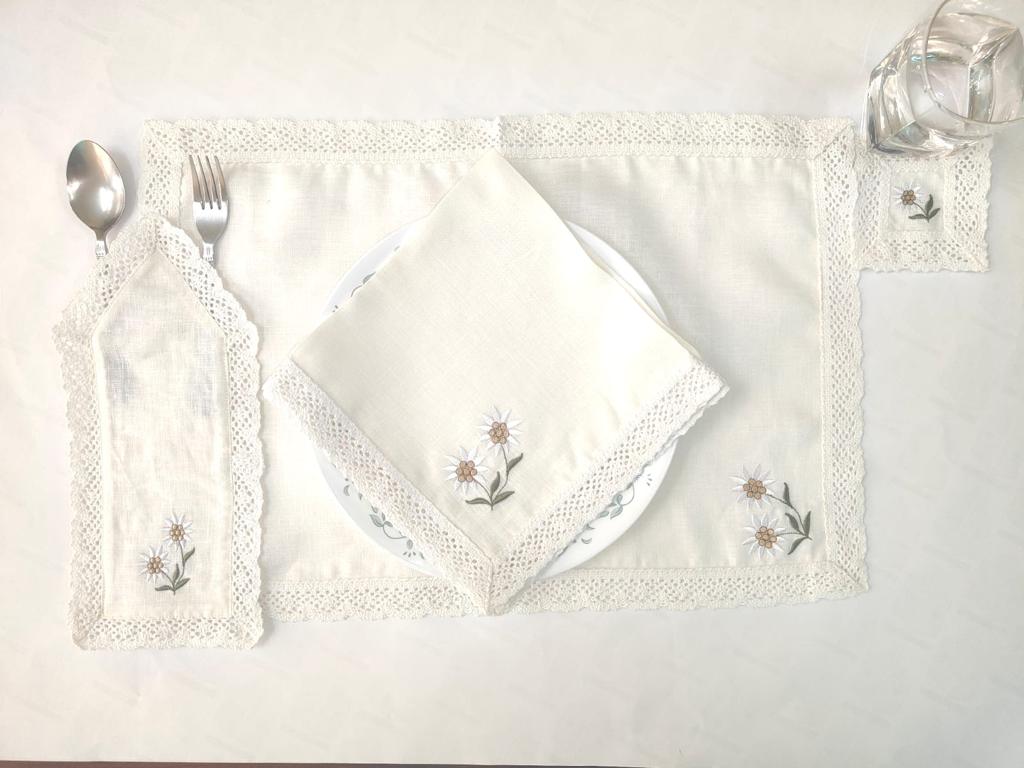 White linen  cutlery holder with floral embroidery.
