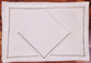 White linen placemats and napkins with gold embroidered border