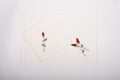 White linen placemats  and napkins with rosebud embroidery.
