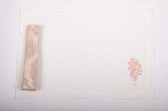 White linen placemats with  fern embroidery with pink and white striped napkins.