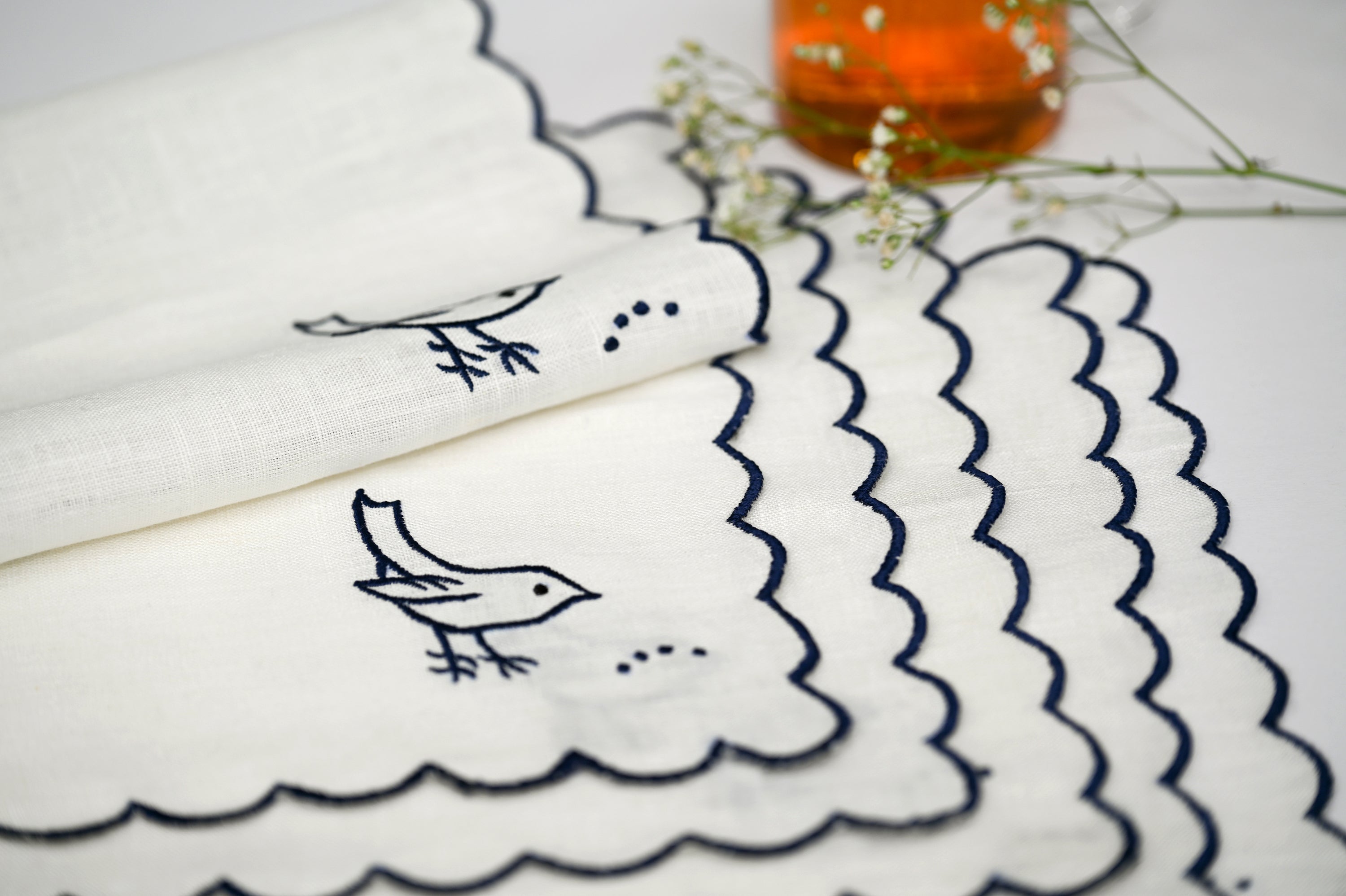 White linen cocktail napkin with bird embroidery