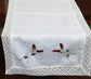 White linen runner with rosebud embroidery and lace detailing.